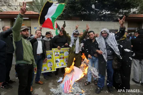 Palestinians burn an Israeli flag and a U.S. flag during a protest against Trump's decision to recognize Jerusalem as the capital of Israel, in front of Red cross office in Gaza city, on December 18, 2017. Photo by Moham...