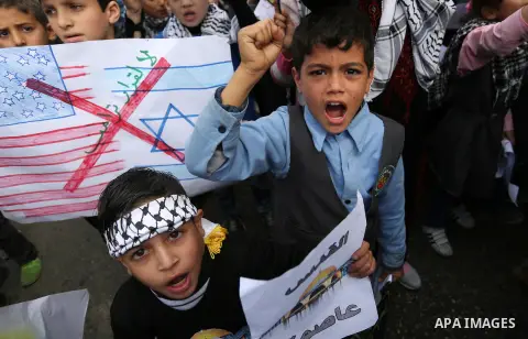 Palestinian children take part in a protest against Trump's decision to recognize Jerusalem as the capital of Israel, in front of the headquarters United Nations Relief and Works Agency (UNRWA) in Gaza city, on December...