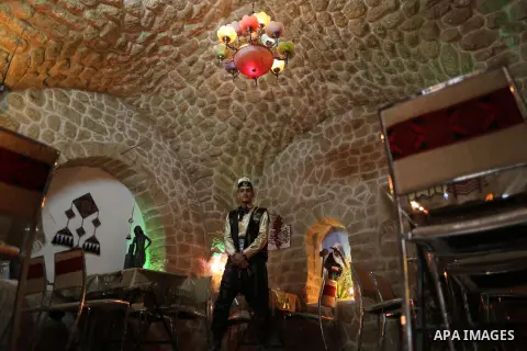 A Palestinian waiter wears a traditional costume as he stands at the "Bait Sitty resturant" in the Old Gaza city on December 19, 2017. Bait Sitty resturant is the first archaeological restaurant in the Gaza Strip which w...
