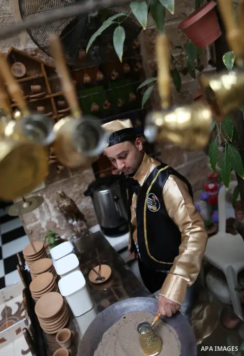 A Palestinian waiter wears a traditional costume as he prepares coffee at the "Bait Sitty resturant" in the Old Gaza city on December 19, 2017. Bait Sitty resturant is the first archaeological restaurant in the Gaza Stri...