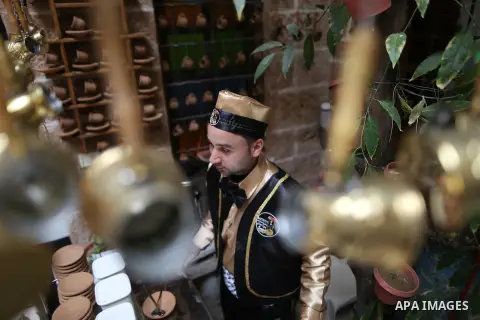 A Palestinian waiter wears a traditional costume as he prepares coffee at the "Bait Sitty resturant" in the Old Gaza city on December 19, 2017. Bait Sitty resturant is the first archaeological restaurant in the Gaza Stri...