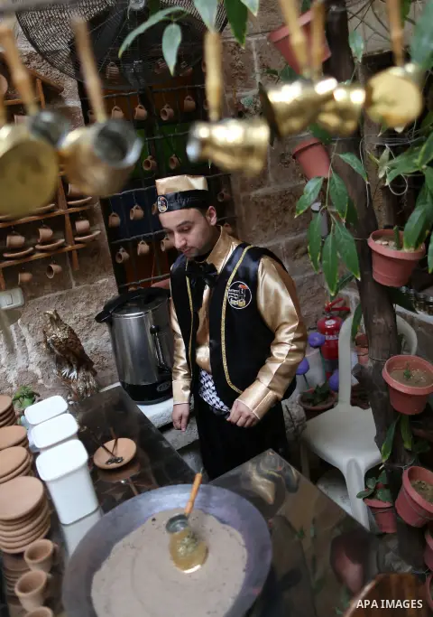 A Palestinian waiter wears a traditional costume as he prepares coffee at the "Bait Sitty resturant" in the Old Gaza city on December 19, 2017. Bait Sitty resturant is the first archaeological restaurant in the Gaza Stri...