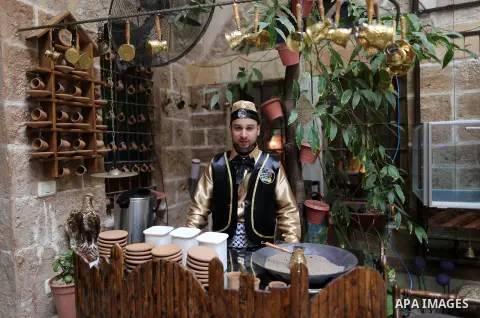 A Palestinian waiter wears a traditional costume as he prepares coffee at the "Bait Sitty resturant" in the Old Gaza city on December 19, 2017. Bait Sitty resturant is the first archaeological restaurant in the Gaza Stri...