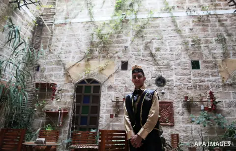 A Palestinian waiter wears a traditional costume as he stands at the "Bait Sitty resturant" in the Old Gaza city on December 19, 2017. Bait Sitty resturant is the first archaeological restaurant in the Gaza Strip which w...