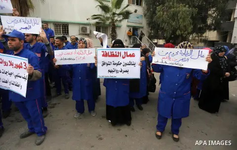 Palestinian cleaners hold banners during a protest to demand their salaries, in Gaza City December 20, 2017. Photo by Mohammed Asad