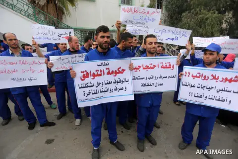 Palestinian cleaners hold banners during a protest to demand their salaries, in Gaza City December 20, 2017. Photo by Mohammed Asad