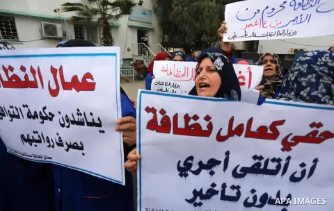 Palestinian cleaners hold banners during a protest to demand their salaries, in Gaza City December 20, 2017. Photo by Mohammed Asad