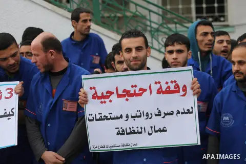 Palestinian cleaners hold banners during a protest to demand their salaries, in Gaza City December 20, 2017. Photo by Mohammed Asad