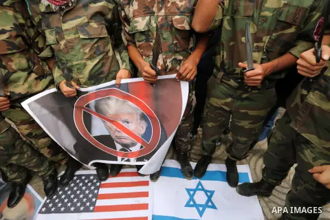 Palestinian supporters of the Popular Front for the Liberation of Palestine (PFLP) burn posters depicting U.S. President Donald Trump, an Israeli flag and a U.S. flag during a protest against U.S. President Donald Trump'...