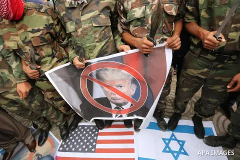 Palestinian supporters of the Popular Front for the Liberation of Palestine (PFLP) burn posters depicting U.S. President Donald Trump, an Israeli flag and a U.S. flag during a protest against U.S. President Donald Trump'...