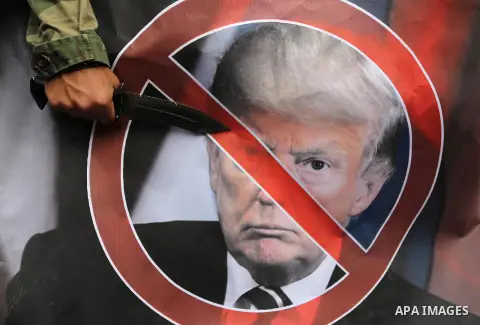 Palestinian supporters of the Popular Front for the Liberation of Palestine (PFLP) burn posters depicting U.S. President Donald Trump, an Israeli flag and a U.S. flag during a protest against U.S. President Donald Trump'...