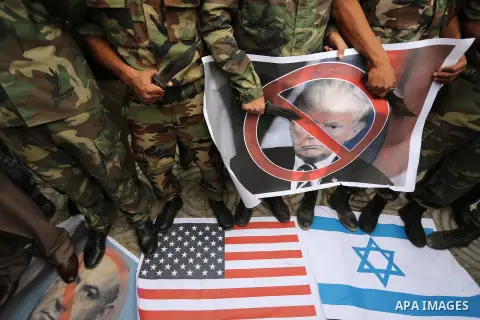 Palestinian supporters of the Popular Front for the Liberation of Palestine (PFLP) burn posters depicting U.S. President Donald Trump, an Israeli flag and a U.S. flag during a protest against U.S. President Donald Trump'...