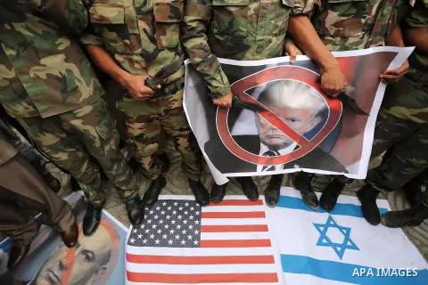 Palestinian supporters of the Popular Front for the Liberation of Palestine (PFLP) burn posters depicting U.S. President Donald Trump, an Israeli flag and a U.S. flag during a protest against U.S. President Donald Trump'...