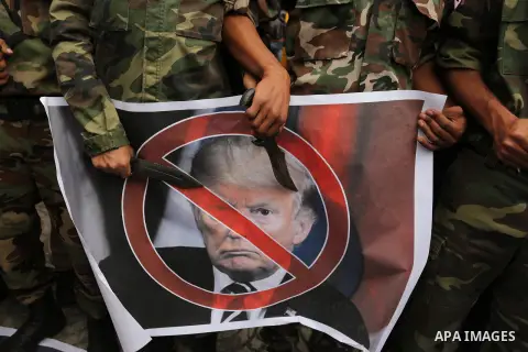 Palestinian supporters of the Popular Front for the Liberation of Palestine (PFLP) burn posters depicting U.S. President Donald Trump, an Israeli flag and a U.S. flag during a protest against U.S. President Donald Trump'...