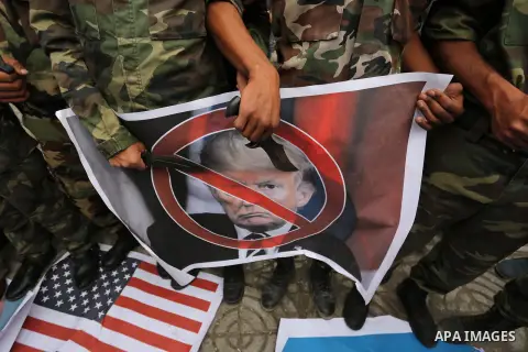 Palestinian supporters of the Popular Front for the Liberation of Palestine (PFLP) burn posters depicting U.S. President Donald Trump, an Israeli flag and a U.S. flag during a protest against U.S. President Donald Trump'...