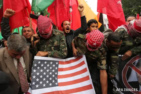 Palestinian supporters of the Popular Front for the Liberation of Palestine (PFLP) burn posters depicting U.S. President Donald Trump, an Israeli flag and a U.S. flag during a protest against U.S. President Donald Trump'...