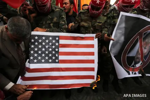 Palestinian supporters of the Popular Front for the Liberation of Palestine (PFLP) burn posters depicting U.S. President Donald Trump, an Israeli flag and a U.S. flag during a protest against U.S. President Donald Trump'...
