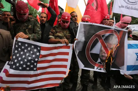 Palestinian supporters of the Popular Front for the Liberation of Palestine (PFLP) burn posters depicting U.S. President Donald Trump, an Israeli flag and a U.S. flag during a protest against U.S. President Donald Trump'...