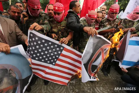Palestinian supporters of the Popular Front for the Liberation of Palestine (PFLP) burn posters depicting U.S. President Donald Trump, an Israeli flag and a U.S. flag during a protest against U.S. President Donald Trump'...
