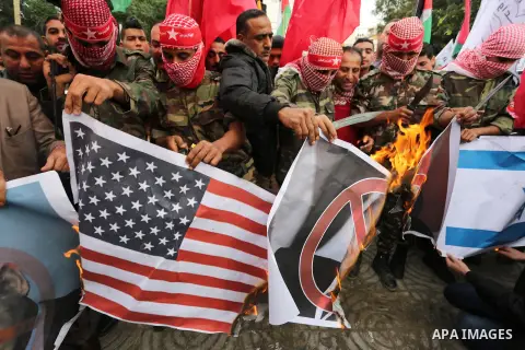 Palestinian supporters of the Popular Front for the Liberation of Palestine (PFLP) burn posters depicting U.S. President Donald Trump, an Israeli flag and a U.S. flag during a protest against U.S. President Donald Trump'...