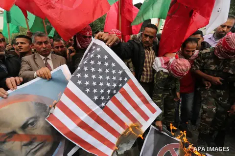 Palestinian supporters of the Popular Front for the Liberation of Palestine (PFLP) burn posters depicting U.S. President Donald Trump, an Israeli flag and a U.S. flag during a protest against U.S. President Donald Trump'...