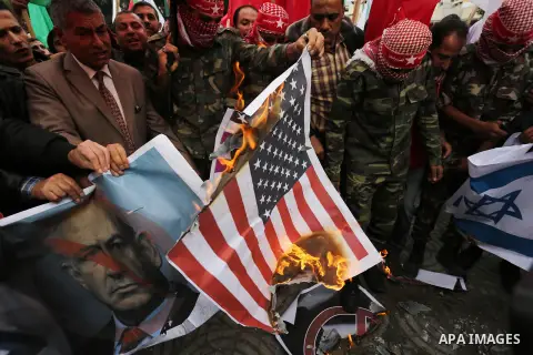 Palestinian supporters of the Popular Front for the Liberation of Palestine (PFLP) burn posters depicting U.S. President Donald Trump, an Israeli flag and a U.S. flag during a protest against U.S. President Donald Trump'...