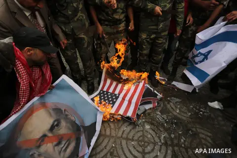 Palestinian supporters of the Popular Front for the Liberation of Palestine (PFLP) burn posters depicting U.S. President Donald Trump, an Israeli flag and a U.S. flag during a protest against U.S. President Donald Trump'...