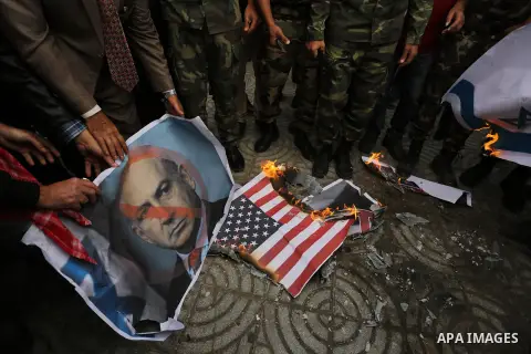 Palestinian supporters of the Popular Front for the Liberation of Palestine (PFLP) burn posters depicting U.S. President Donald Trump, an Israeli flag and a U.S. flag during a protest against U.S. President Donald Trump'...