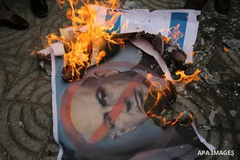 Palestinian supporters of the Popular Front for the Liberation of Palestine (PFLP) burn posters depicting U.S. President Donald Trump, an Israeli flag and a U.S. flag during a protest against U.S. President Donald Trump'...