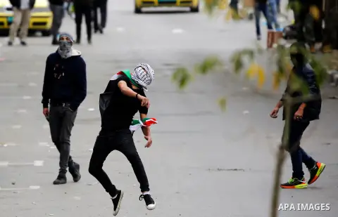 Palestinian protesters hurl stones toward Israeli security forces during clashes following a protest against U.S. President Donald Trump's decision to recognise Jerusalem as the capital of Israel, in the West Bank city o...