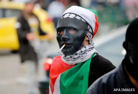 A Palestinian protester smokes during clashes with Israeli security forces following a protest against U.S. President Donald Trump's decision to recognise Jerusalem as the capital of Israel, in the West Bank city of Hebr...