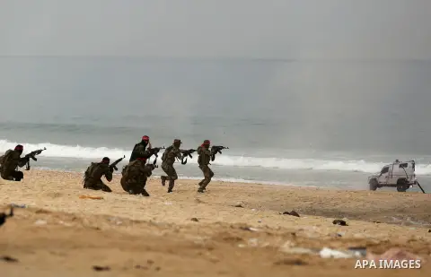 Palestinian militants of the Popular Front for the Liberation of Palestine (PFLP) take part in a military exercise, on beach in Khan Younis in the southern Gaza Strip, December 22, 2017. Photo by Ashraf Amra
