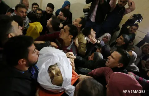 Palestinian mourners carry the body of Mohamed Moheisen, 29, who was killed during clashes with Israeli troops, during his funeral in Gaza city on December 23, 2017. Two Palestinians were killed as youths clashed with Is...