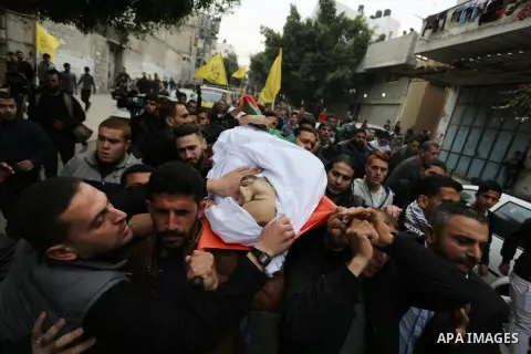 Palestinian mourners carry the body of Mohamed Moheisen, 29, who was killed during clashes with Israeli troops, during his funeral in Gaza city on December 23, 2017. Two Palestinians were killed as youths clashed with Is...