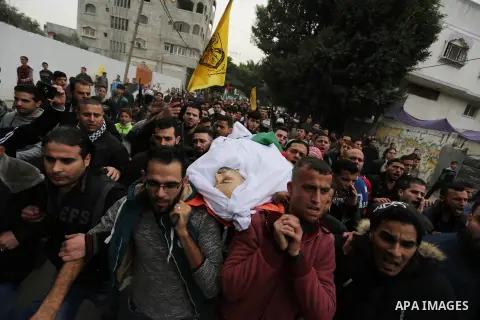 Palestinian mourners carry the body of Mohamed Moheisen, 29, who was killed during clashes with Israeli troops, during his funeral in Gaza city on December 23, 2017. Two Palestinians were killed as youths clashed with Is...