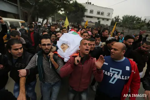 Palestinian mourners carry the body of Mohamed Moheisen, 29, who was killed during clashes with Israeli troops, during his funeral in Gaza city on December 23, 2017. Two Palestinians were killed as youths clashed with Is...