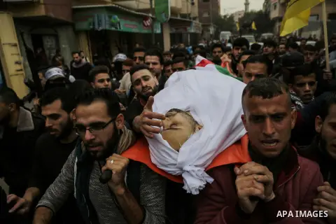 Palestinian mourners carry the body of Mohamed Moheisen, 29, who was killed during clashes with Israeli troops, during his funeral in Gaza city on December 23, 2017. Two Palestinians were killed as youths clashed with Is...