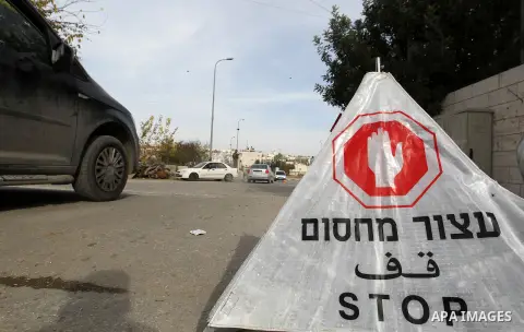 Israeli soldiers check the ID of Palestinian drivers as they inspect a vehicle at a checkpoint in the West Bank city of Hebron, on December 23, 2017. Photo by Wisam Hashlamoun