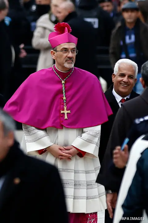 Archbishop Pierbattista Pizzaballa, Apostolic Administrator of the Latin Patriarchate of Jerusalem, walks past a giant Christmas tree during a procession at the Church of the Nativity compound in the West Bank city of Be...