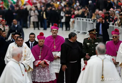 Archbishop Pierbattista Pizzaballa, Apostolic Administrator of the Latin Patriarchate of Jerusalem, walks past a giant Christmas tree during a procession at the Church of the Nativity compound in the West Bank city of Be...