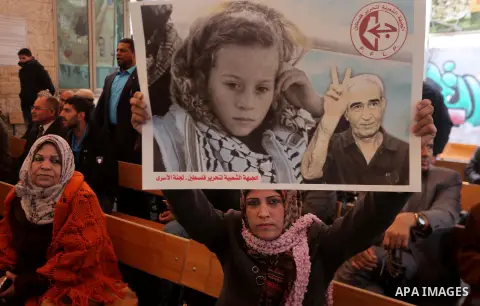 Palestinians hold poster of Ahed Tamimi during a protest to show solidarity with Palestinian prisoners held in Israeli jails, in front of Red cross office in Gaza city, on December 25, 2017. Photo by Mohammed Asad
