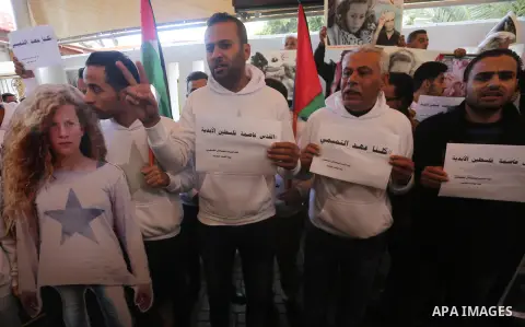 Palestinians hold poster of Ahed Tamimi during a protest to show solidarity with Palestinian prisoners held in Israeli jails, in front of Red cross office in Gaza city, on December 25, 2017. Photo by Mohammed Asad
