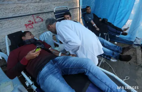 Palestinian men donate blood for the wounded in Israeli jails, in front of Red cross office in Gaza city, on December 25, 2017. Photo by Mohammed Asad