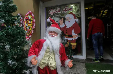 A Palestinian vendor displays decorations of New Year 2018, at his shop in Gaza city on December 25, 2017. Photo by Mohammed Dahman