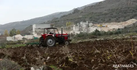 An elderly Palestinian farmer rides his tractor during clashes between Palestinian protesters and Israeli security forces near the Huwwara checkpoint, near the West Bank city of Nablus on December 27, 2017. Photo by Shad...