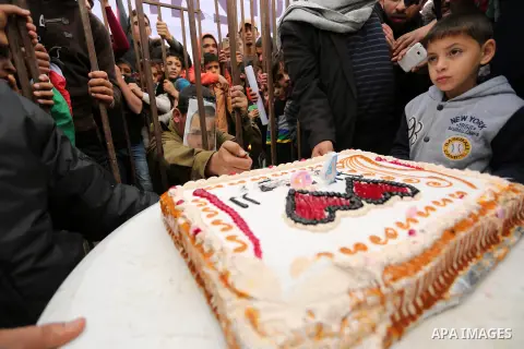 A Palestinian man playing the role of Israeli soldier Oron Shaul is seen in a mock jail as he tries to participate in a birthday party, during a rally in solidarity with Palestinian prisoners held in Israeli jails, in th...
