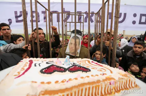 A Palestinian man playing the role of Israeli soldier Oron Shaul is seen in a mock jail as he tries to participate in a birthday party, during a rally in solidarity with Palestinian prisoners held in Israeli jails, in th...
