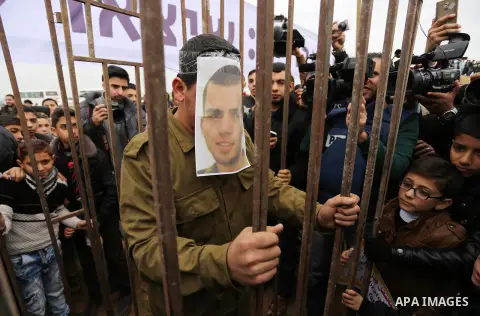 A Palestinian man playing the role of Israeli soldier Oron Shaul stands in a mock jail during a rally in solidarity with Palestinian prisoners held in Israeli jails, in the northern Gaza Strip December 29, 2017. Photo by...