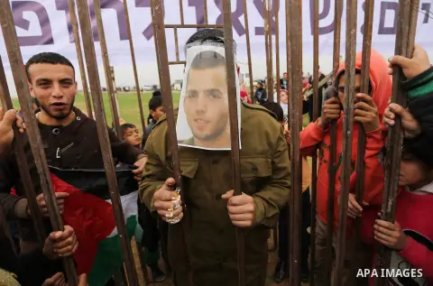 A Palestinian man playing the role of Israeli soldier Oron Shaul stands in a mock jail during a rally in solidarity with Palestinian prisoners held in Israeli jails, in the northern Gaza Strip December 29, 2017. Photo by...