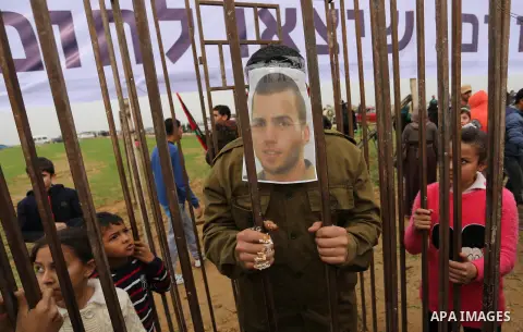 A Palestinian man playing the role of Israeli soldier Oron Shaul stands in a mock jail during a rally in solidarity with Palestinian prisoners held in Israeli jails, in the northern Gaza Strip December 29, 2017. Photo by...